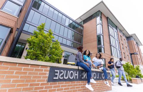 Students sitting 和 talking in front of Hugo Owens residence hall